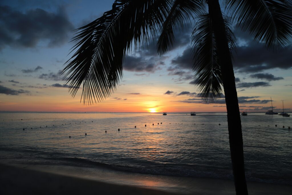 a beautiful sunside on the beach in Barbados. Enjoying a sunset is one of my top Barbados travel tips! 