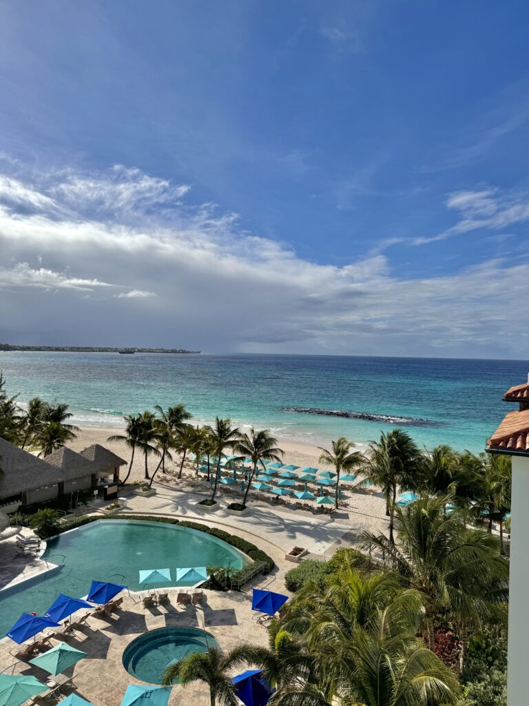 A picture of a Sandals resort in Barbados. A pool overlooking the blue ocean.